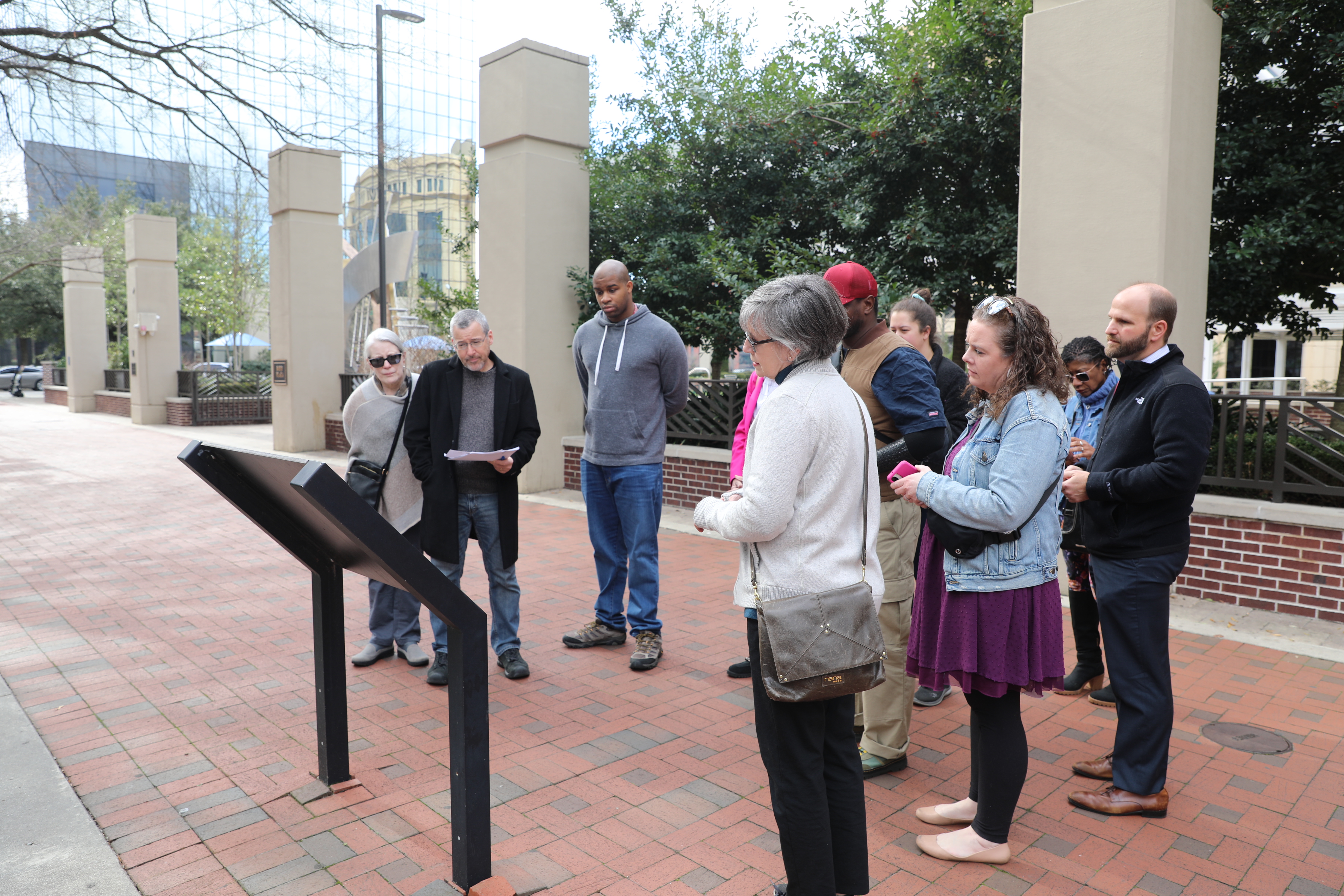 Walking tour participants read a sign along Main Street in downtown Columbia.
