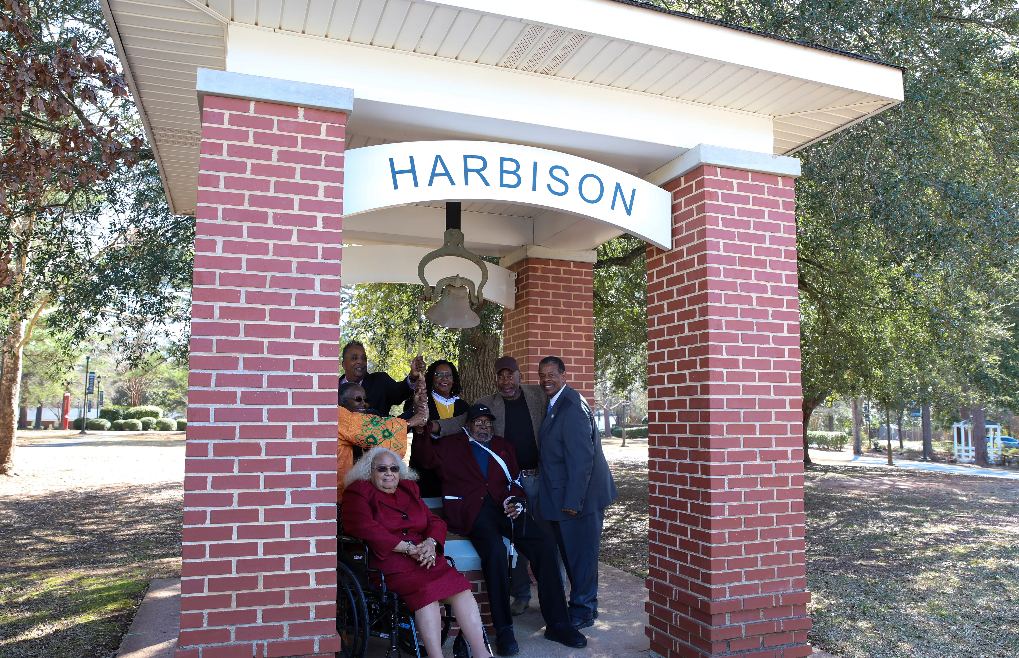 Image of the Harbison bell tower on the Harbison campus. In it are graduates of the Harbison Institute, Dr. Rhames, Mack Jackson, and Sandra Jackson.