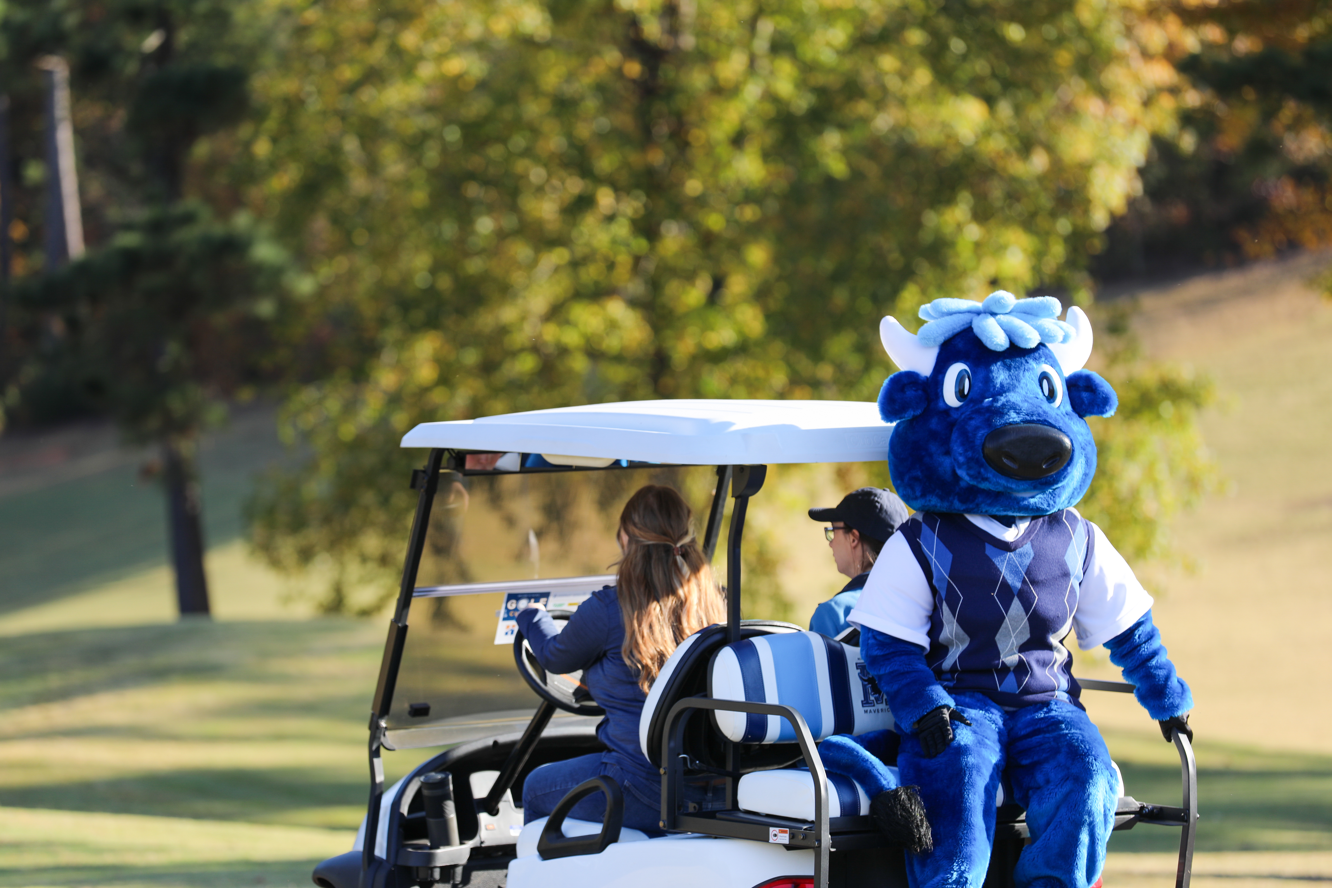 Mav the mascot on a golf cart at the annual MTC golf classic.