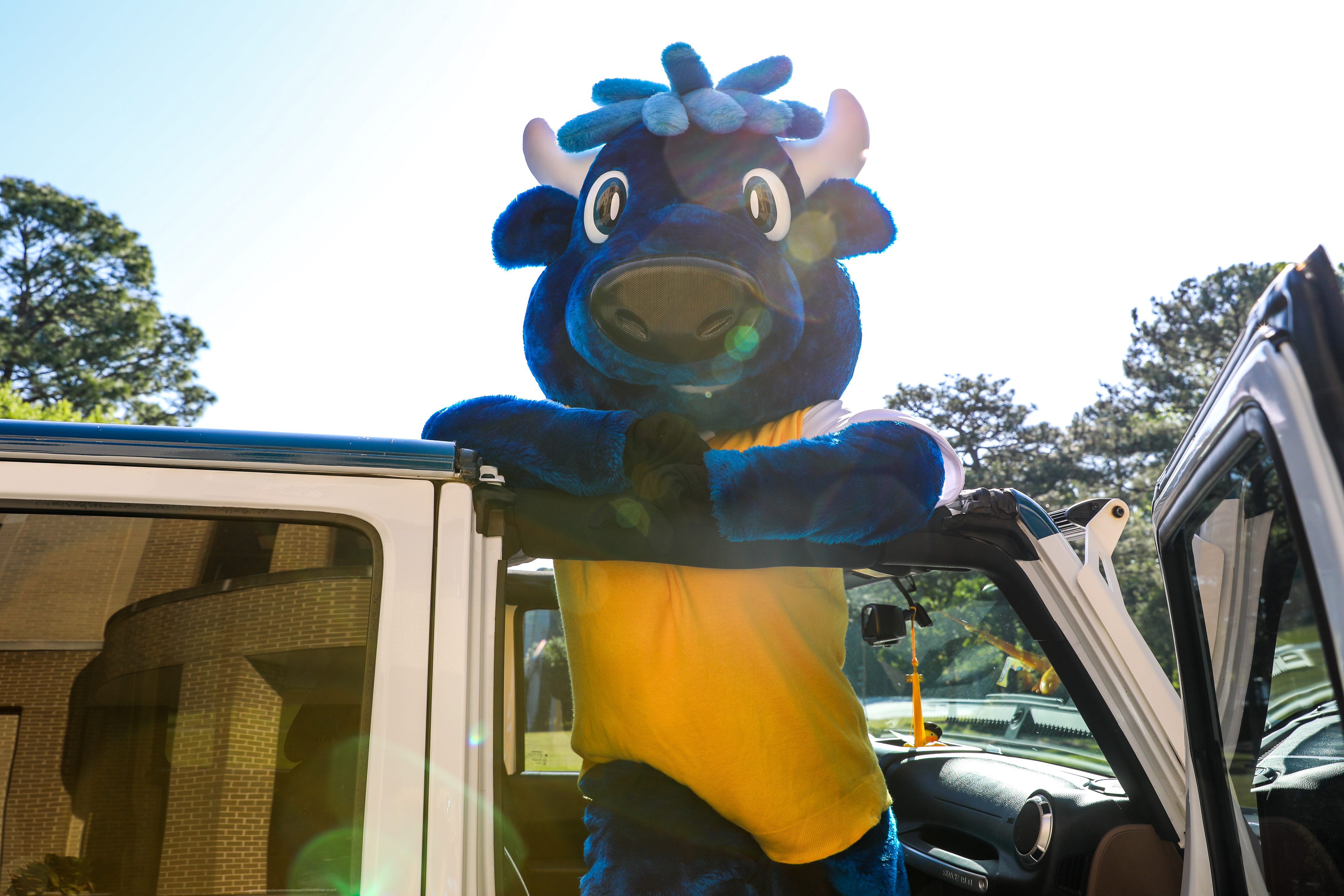 Mav the Mascot posing for a picture in the MTC Jeep