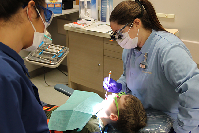 Dental assistants examining child patient