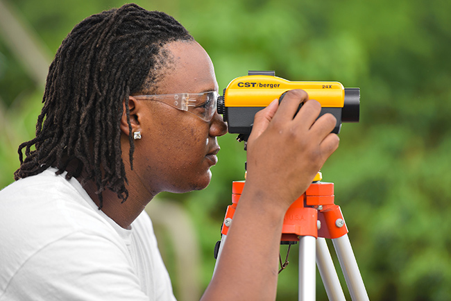 Student looking through surveying equipment