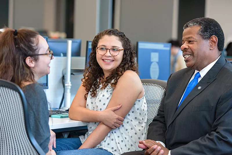 Dr. Rhames with two students