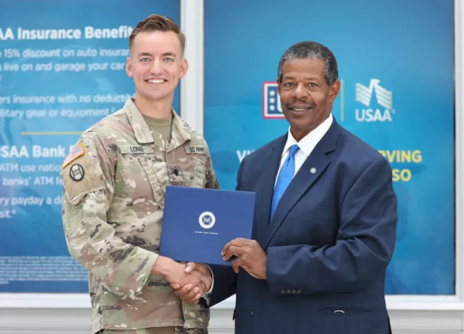 Dr. Ronald Rhames presented a diploma and academic certificate to Spec. Doug Long