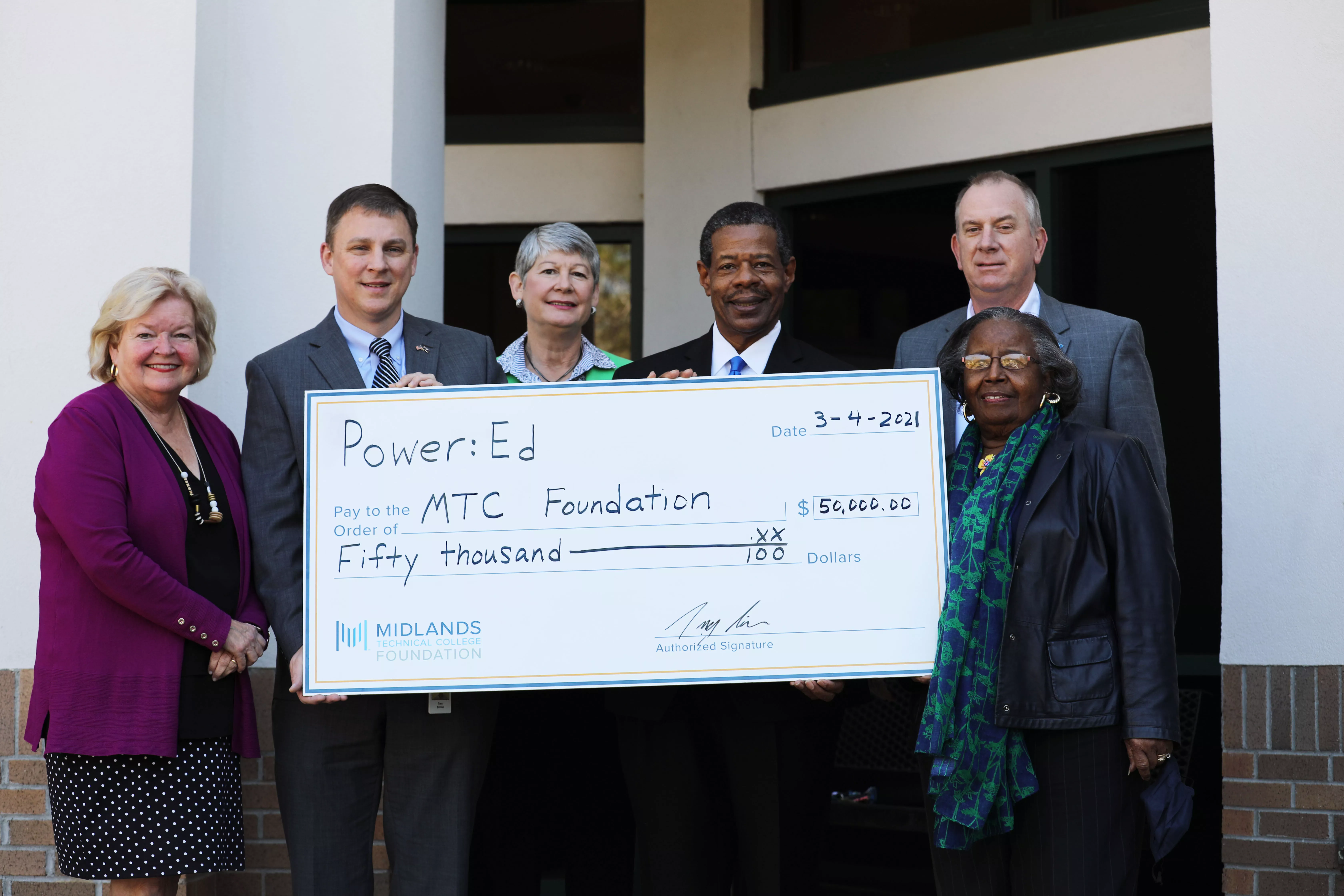 Group of people holding check