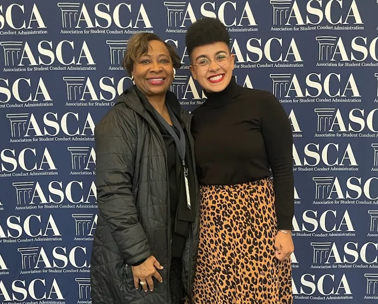 Dr. Mary Holloway with ASCA President Christina Parle standing in front of ASCA backdrop
