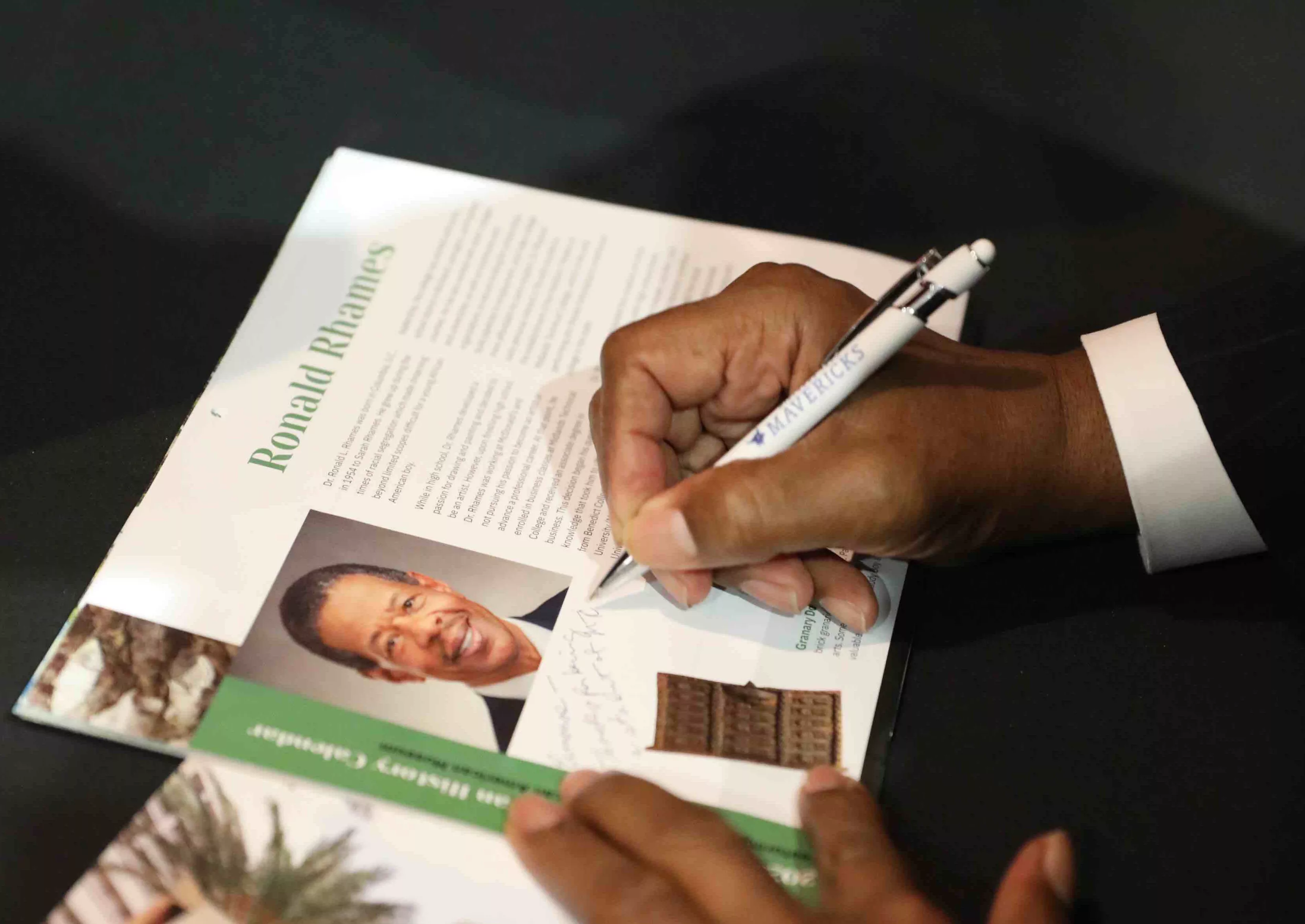 Dr. Rhames signs his profile feature in the 2023 S.C. African American History Calendar.