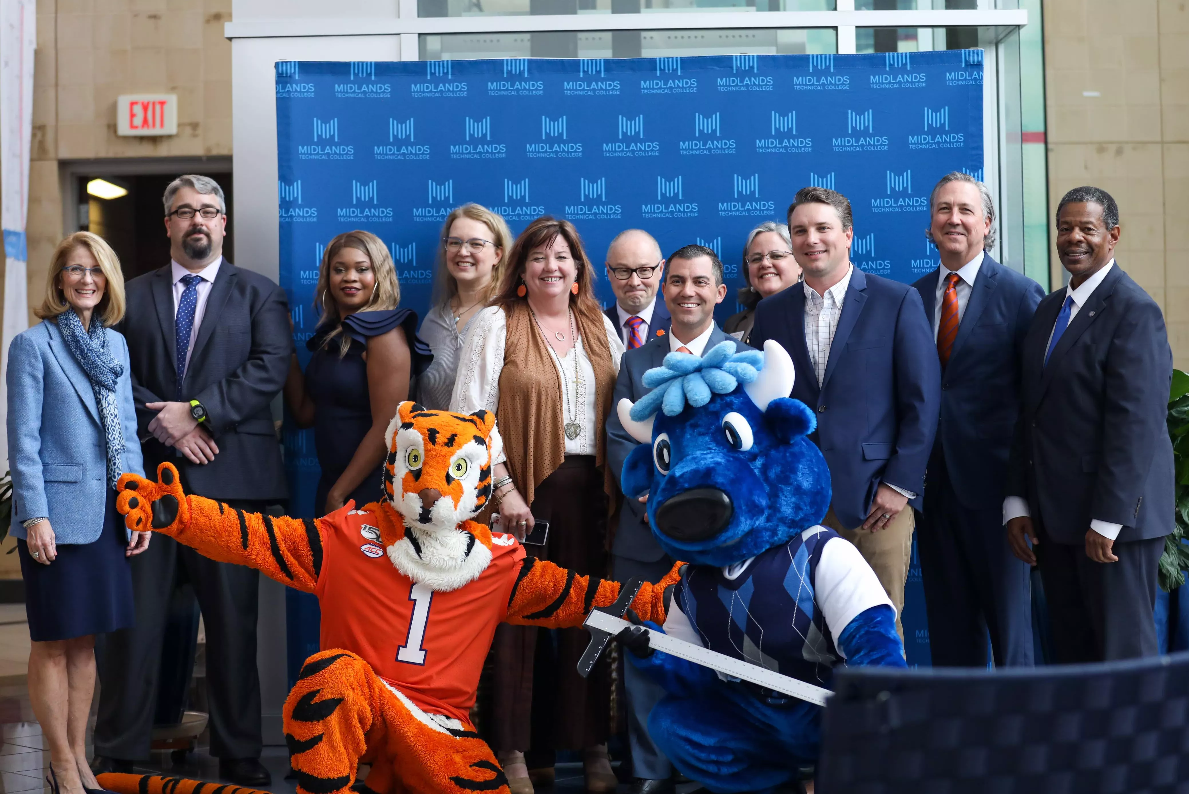 MTC and Clemson officials smiling together with the Clemson and MTC Mascot posing in front