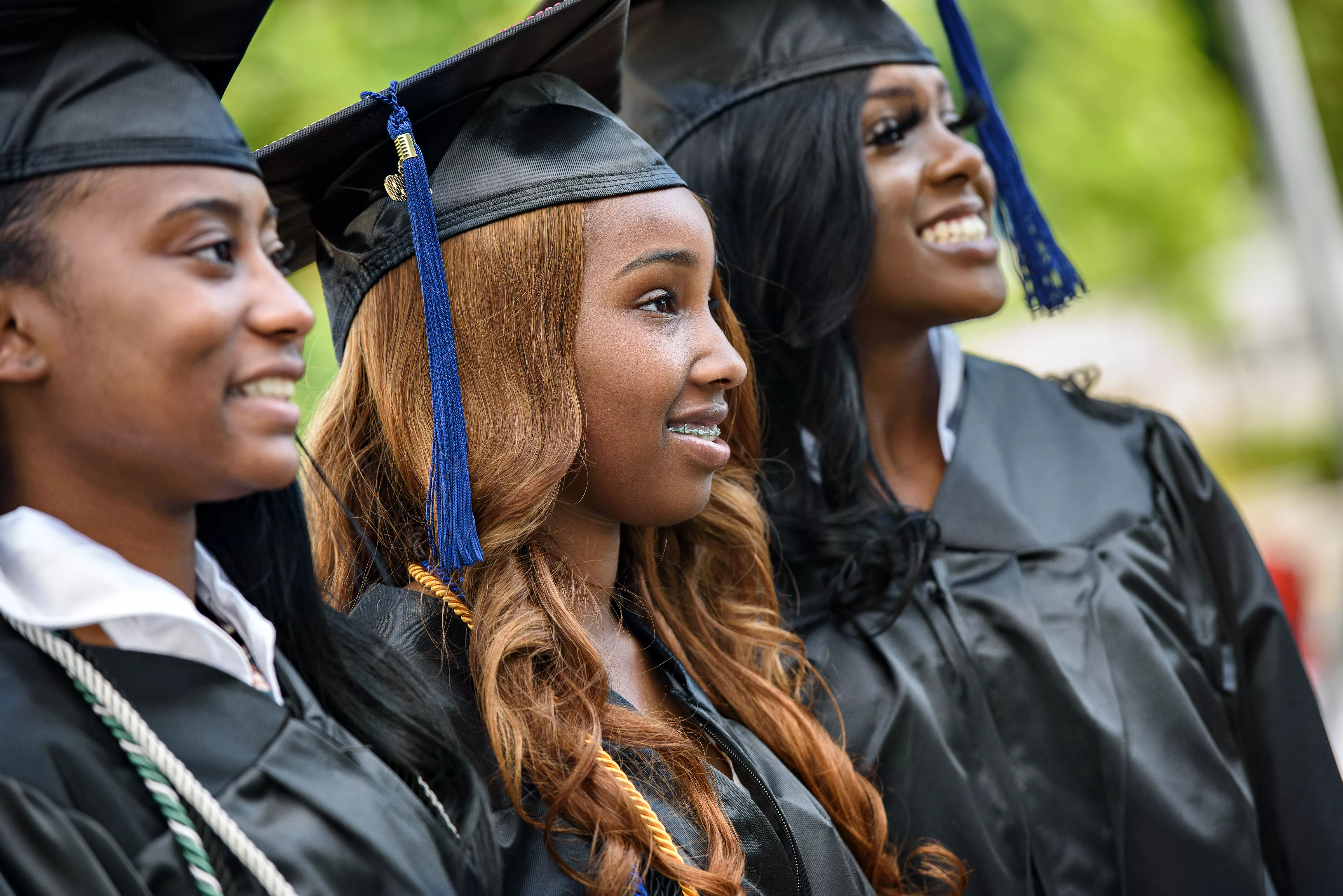 Image of three African American females wearing black graduation regalia.