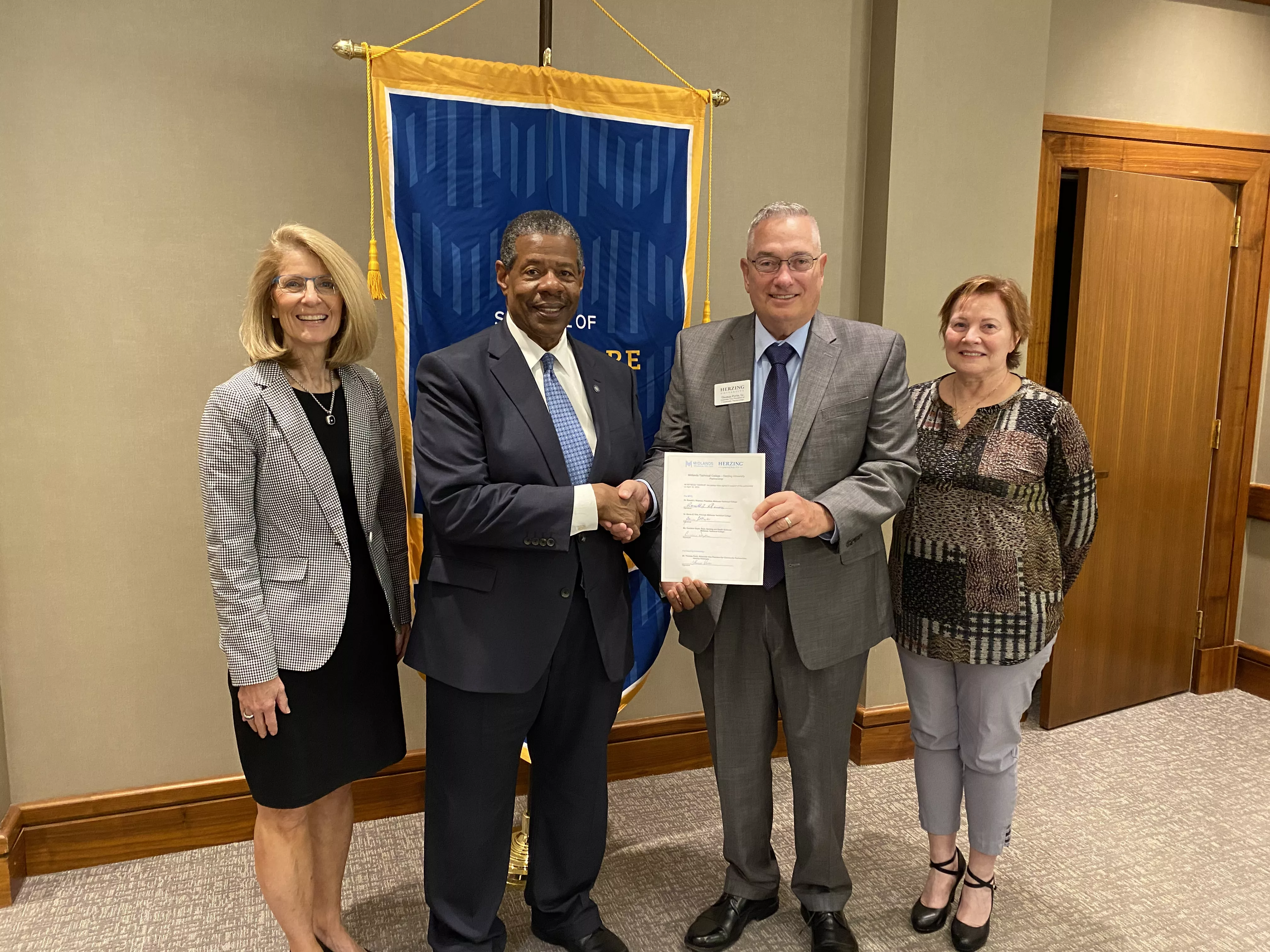 MTC President Dr. Ron Rhames, Provost Barrie Kirk, Dean Candace Doyle, and Herzing Rep, Thomas Perin, pose together with the signed articulation agreement.