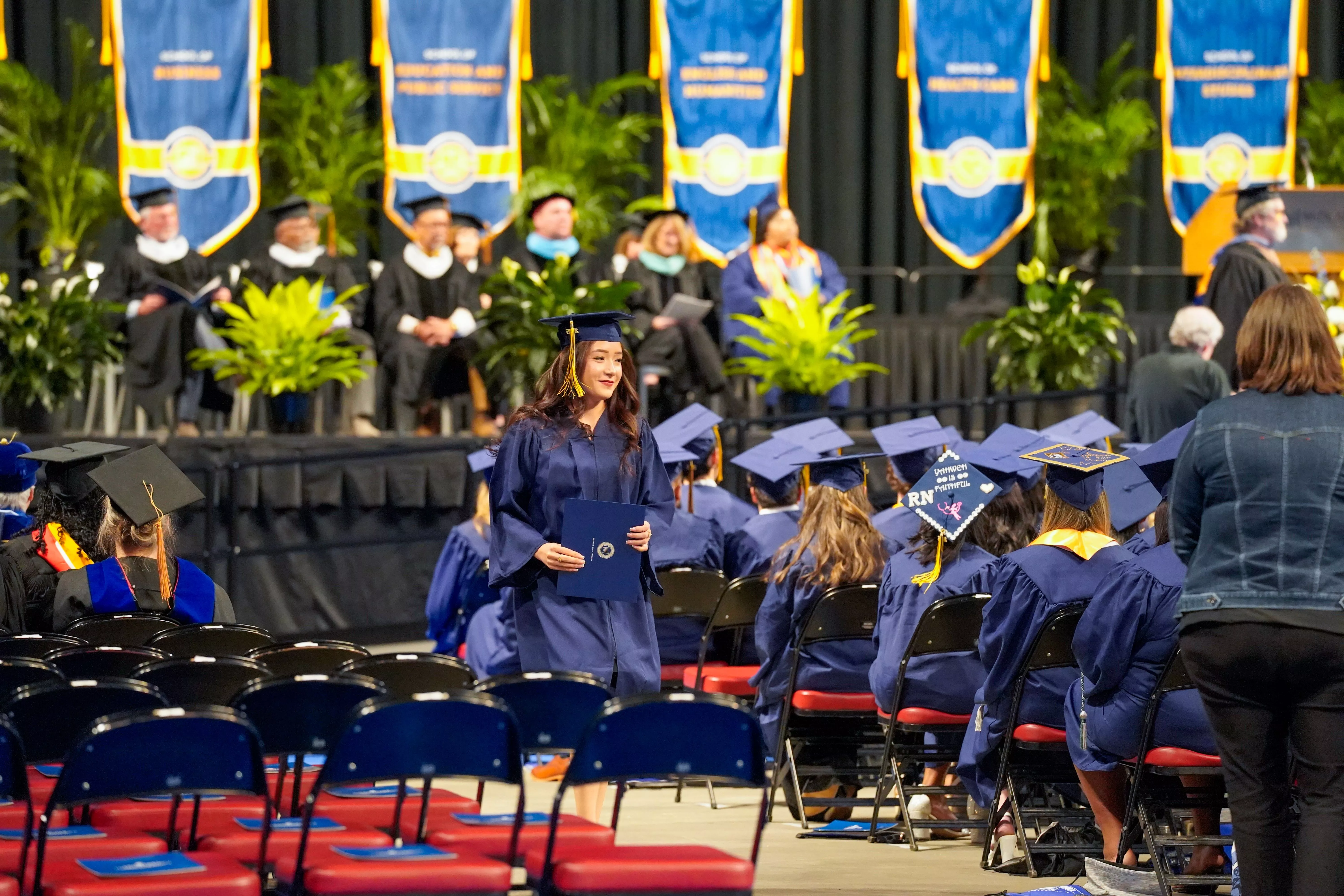Graduate with diploma returning to her seat