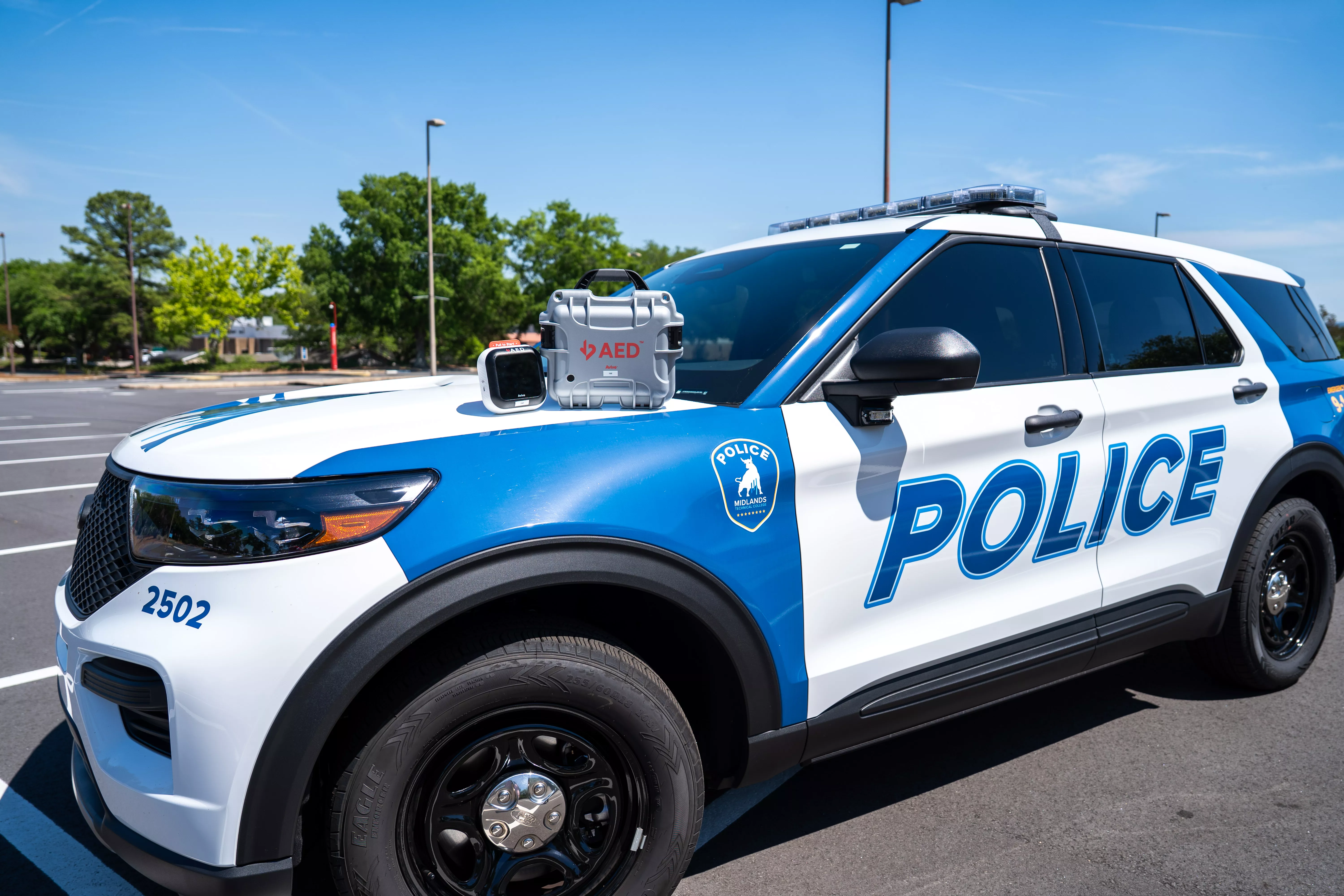 Midlands Technical College police SUV with Avive automated external defibrillator sitting on hood of car.
