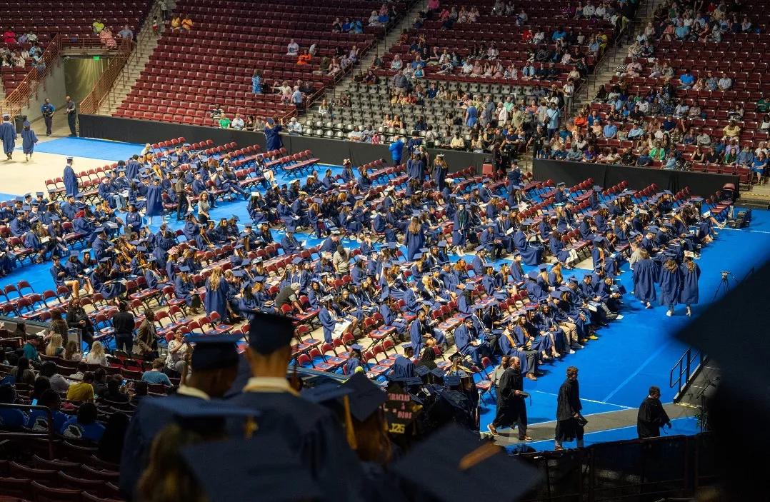 Midlands Technical College graduates walking down stairs to floor of arena to be seated for ceremony.