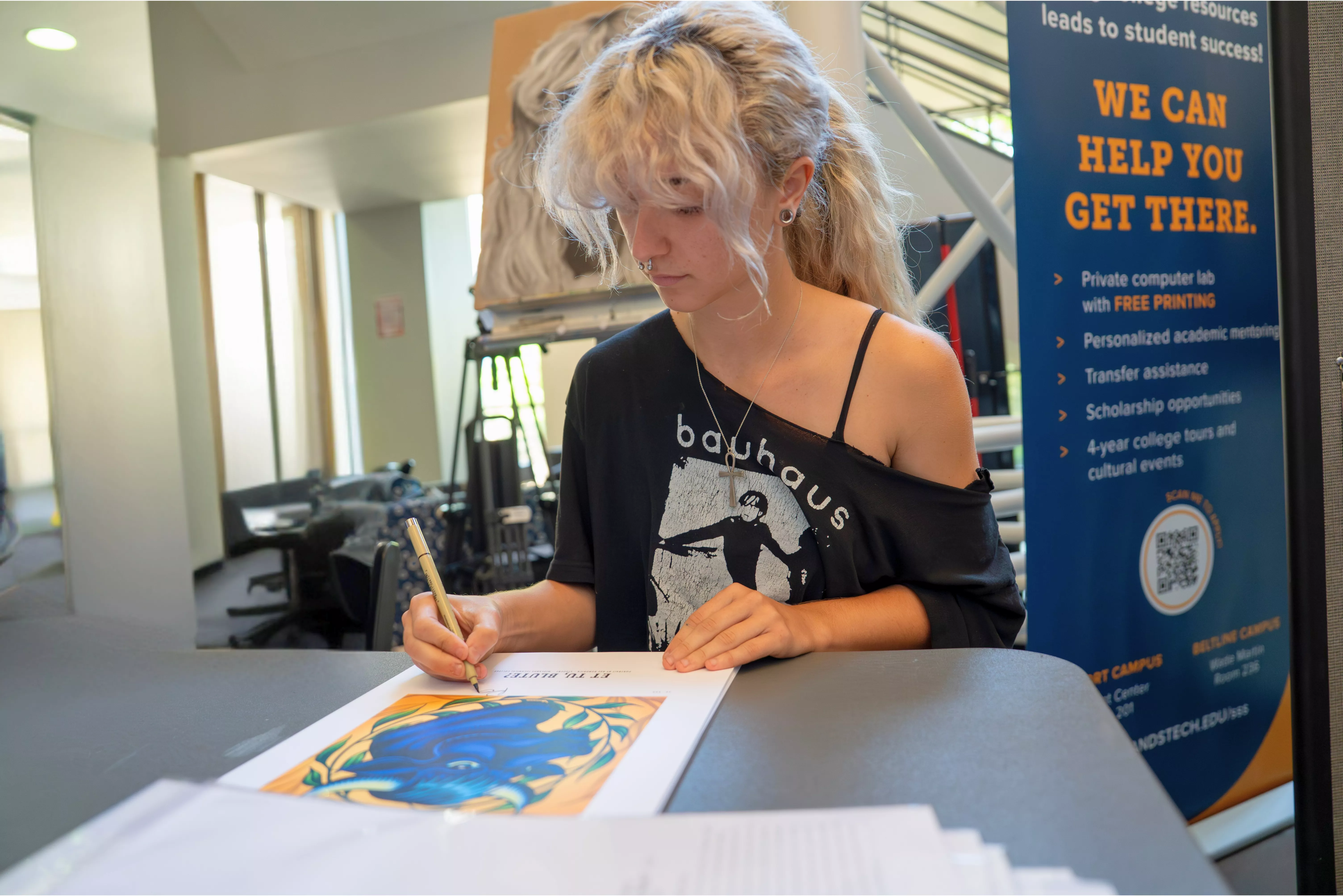 Rae Bundrick signing prints of her artwork.